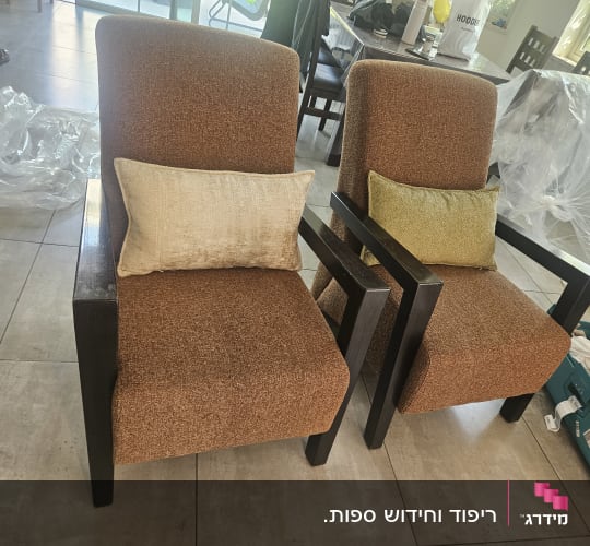 שתי כורסאות עץ מרופדות מחדש בבד חום עם כריות נוי